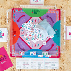 Mahjong for kids. Photo views the game set with colorful components on a wooden surface.